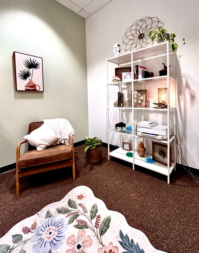 Warm therapy office with cozy chair and bookshelf