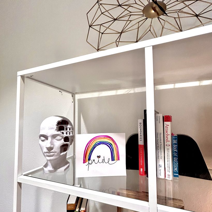 Pride artwork on office bookshelf — LGBTQ+ affirming care